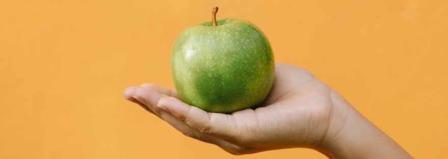fresh apple on hand of woman