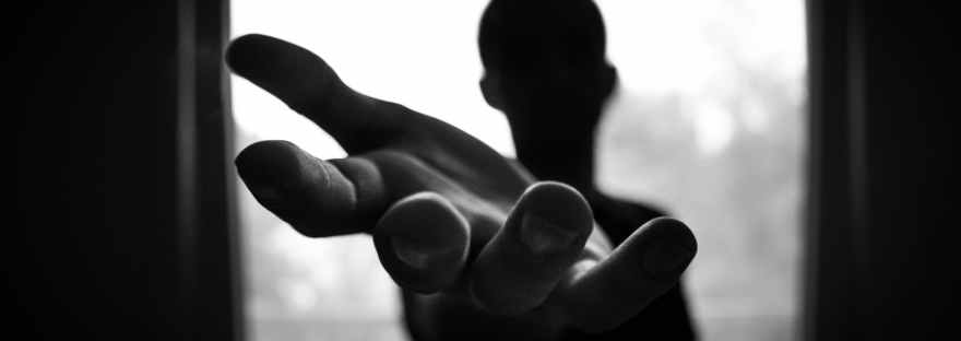 man s hand in shallow focus and grayscale photography