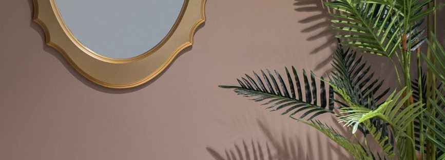 room with potted plant near mirror and table